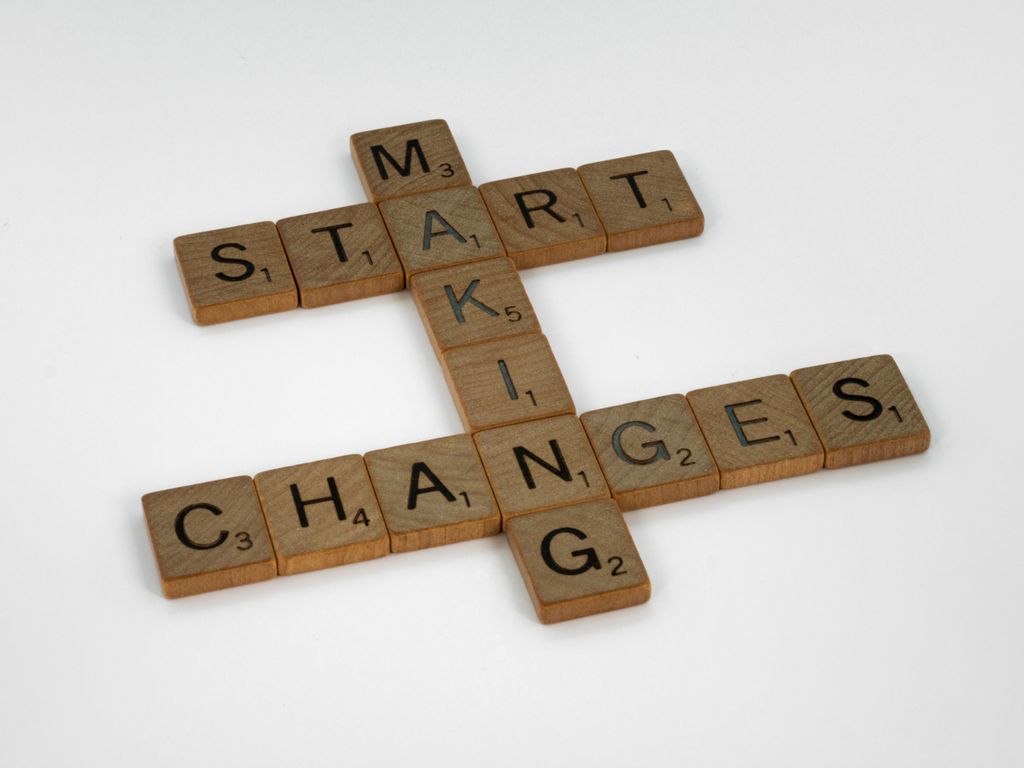 Top view of Scrabble tiles forming the phrase 'Start Making Changes' on a white background.